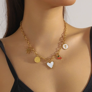 Golden chain necklace with sun, floral coin, white heart, and cherry charms worn by model