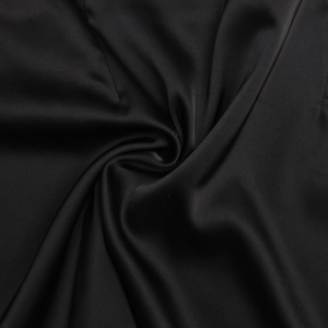 Close-up of black satin fabric with smooth glossy texture and elegant drapes for summer set