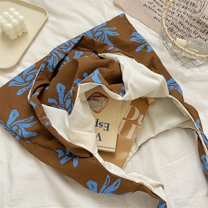 Detail of blue floral canvas tote bag with brown fabric on soft cotton background
