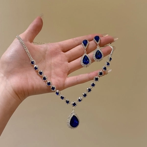 Close-up of deep blue teardrop zircon jewelry set including necklace and earrings