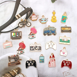 Flat lay of vintage enamel alloy DIY charms including sewing machine and camera