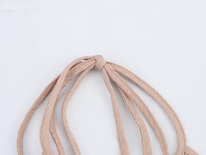 Détail des bretelles en tissu texturé abricot avec nœuds pour cet ensemble de vacances
