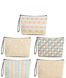 Detail display of cartoon bear and strawberry prints on zipper cosmetic bags with wristlets