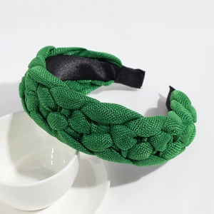 Macro detail of emerald green braided fabric headband with thick woven texture