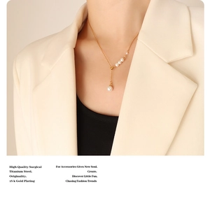 Detail of 18k gold plated titanium steel necklace featuring elegant white pearls