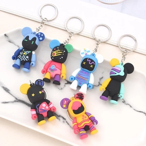 Set of 6 astronaut bear keychains with colorful cosmic patterns on a marble tray