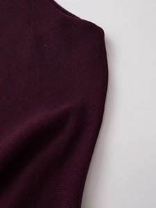 Macro shot of dark purple knitted fabric showing fine stitching and soft texture details