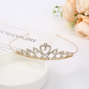 Detailed macro view of heart-shaped gold bridal tiara crown with sparkling white rhinestones