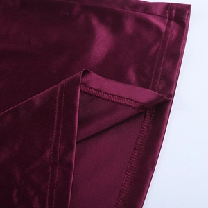 Détail de près du tissu satiné bordeaux avec couture premium et texture brillante