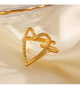 Detailed macro of 18K gold plated heart ring featuring hammered texture on silk