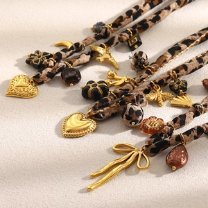 Détail de pendentifs cœur et lune plaqués or 18 carats avec accents en tissu léopard