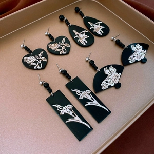 Vintage black and white heart shell pattern earring set on elegant metallic tray