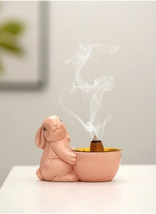 Pink ceramic rabbit incense burner with a golden rim bowl and rising smoke detail