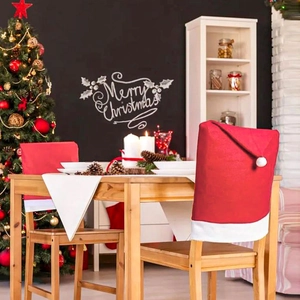 Detail of red Santa hat chair covers in a cozy decorated Christmas dining room setting