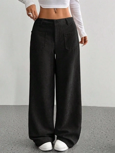 Dettaglio dei pantaloni a gamba larga in velluto a coste nere con vita alta e texture