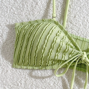 Nahaufnahme des hellgrünen Bikini-Oberteils mit gewellter Textur und seitlichem Bindeband