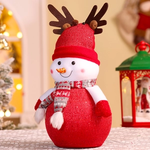 Detail of a Christmas snowman ornament with red knit hat, antlers, and striped scarf texture