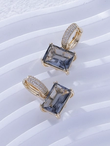 Detail of gold hoop earrings with smoky grey rectangular zircon and micro-pave setting