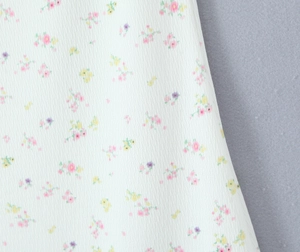 Gros plan sur un tissu en maille côtelée blanche avec des motifs floraux délicats
