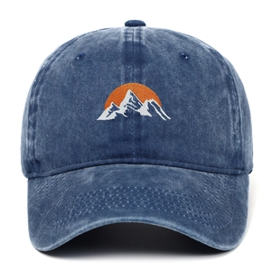 Close-up of mountain and sun embroidery on washed blue cotton baseball cap fabric