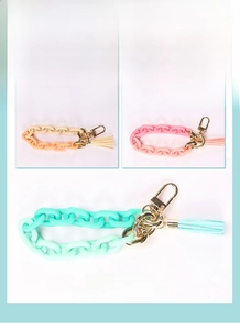 Detail of colorful acrylic chain wristlet with leather tassel and gold spring buckle