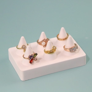 Minimalist resin jewelry display stand with golden pearl and zircon rings on light blue base