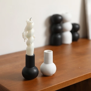 Minimalist black and white ceramic candle holders with a round base and sleek modern design