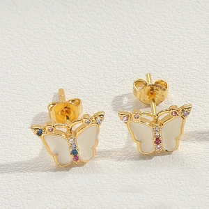 Macro shot of gold butterfly stud earrings with white inlay and colorful crystals