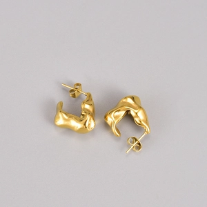 Detailed view of gold irregular lava textured earrings with metallic gloss finish