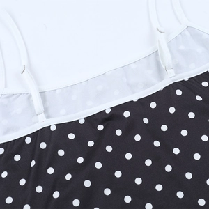 Détail des bretelles réglables et du tissu à pois sur une robe courte moulante