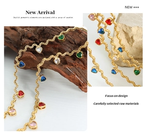 Detailed macro shot of gold wave chain featuring colorful heart-shaped zircon pendants