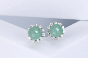 Detail view of round green aventurine stud earrings with a halo of white zircon stones