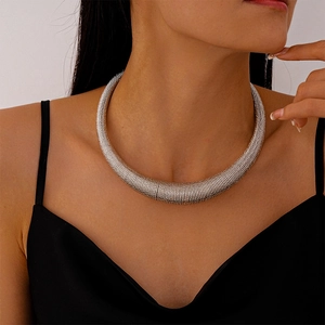 Macro view of silver chunky ribbed metal collar necklace on model neck