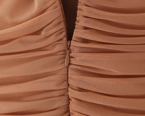 Détail de la fermeture éclair invisible sur tissu en tulle froncé couleur caramel