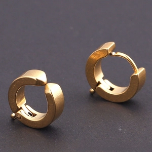Macro view of gold-plated stainless steel huggie earrings with a matte brushed finish