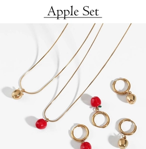 Vue détaillée d'une parure bijoux pomme avec colliers et boucles d'oreilles or et rouges