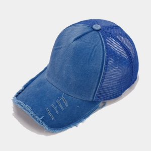 Dettaglio del cappello trucker in denim blu con rete e bordo consumato effetto vintage