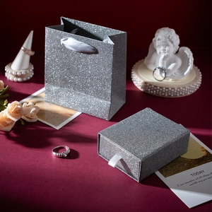 Silver glitter drawer jewelry box and matching gift bag set on dark red background