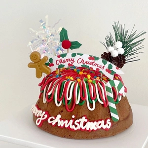Macro detail of Christmas cake topper with gingerbread man and pinecone decorations