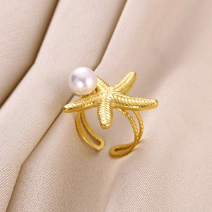 Detail of a gold starfish ring with a round pearl inlay and an adjustable open band
