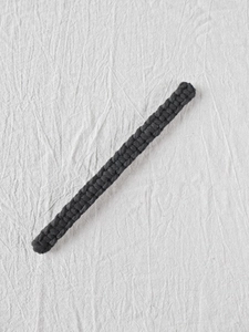 Detail of hand-woven black cotton curtain tieback showing intricate bohemian rope textures