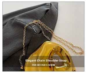 Detail shot of a golden metallic crossbody bag with a sleek mirror finish and link chain