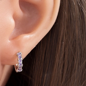 Orecchini a cerchio placcati in argento con zirconi viola indossati da un modello