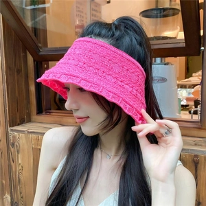 Dettaglio cappello parasole intrecciato a mano rosso rosa con design aperto su modella