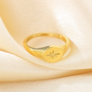 Macro shot of 18K gold plated stainless steel signet ring with starburst engraving