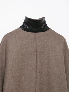 Dettaglio del retro di un cappotto in lana marrone con colletto alla coreana in pelle nera