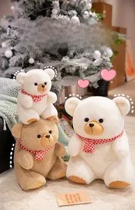 Detail of soft plush teddy bears in brown and white wearing red checkered scarves