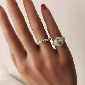Detail of elegant silver ring set featuring micro-pave white crystals on a model hand