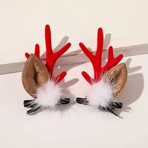 Detail of Christmas reindeer antler hair clips with red flocking and white fur pom-poms