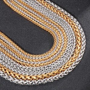 Detail of woven hip hop style dragon bone chain necklaces in gold and silver finish